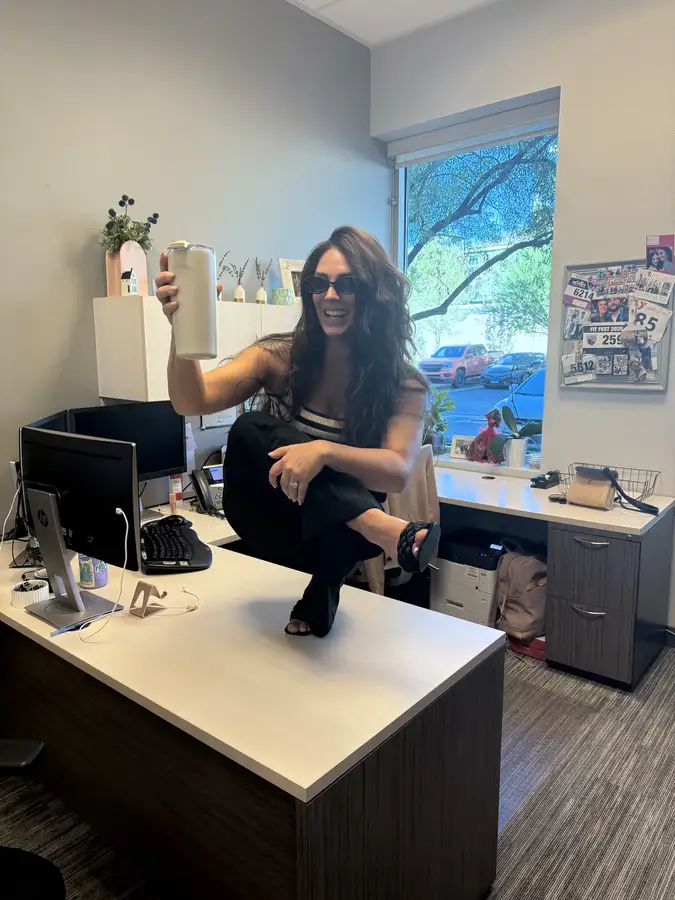 Briana striking a pose on her desk